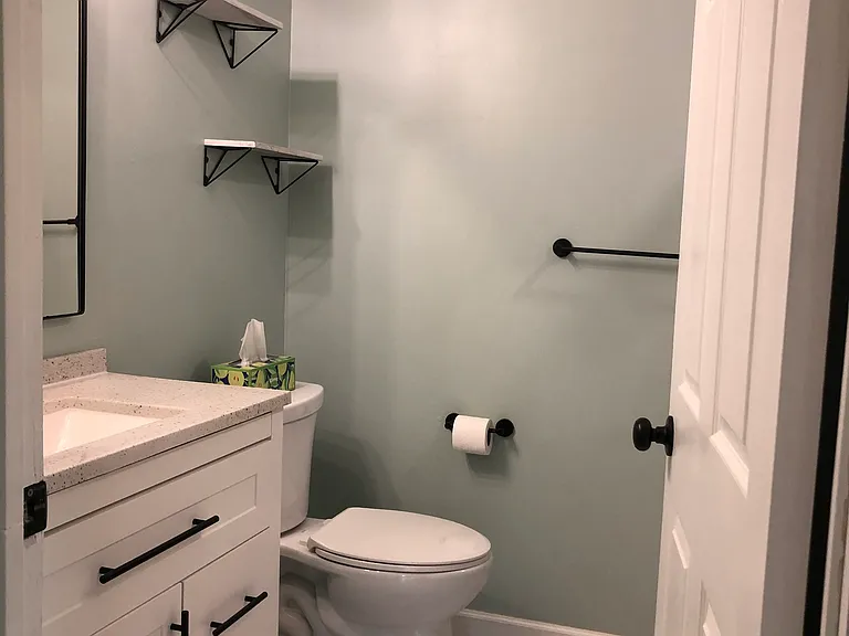 master bathroom updated with new tile floor, toilet, and vanity
