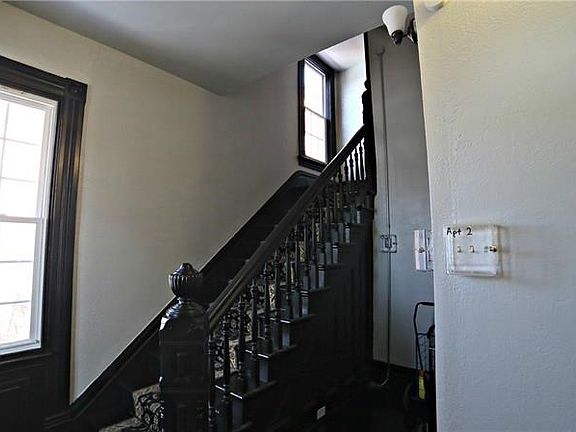 ENTRYWAY INTO BUILDING - FRESHLY PAINTED WITH ORIGINAL HAND CARVED STAIRCASE - BEAUTIFUL BALUSTRADE IS OFFSET BY  LARGE, FRAMED 
