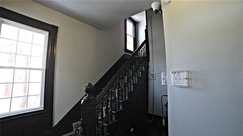 ENTRYWAY INTO BUILDING - FRESHLY PAINTED WITH ORIGINAL HAND CARVED STAIRCASE - BEAUTIFUL BALUSTRADE IS OFFSET BY  LARGE, FRAMED 