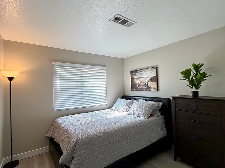 Comfortable and fully furnished third bedroom featuring a bright, inviting atmosphere and stylish decor.