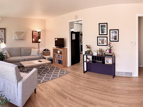 Living room with kitchen access and hallway to bedrooms