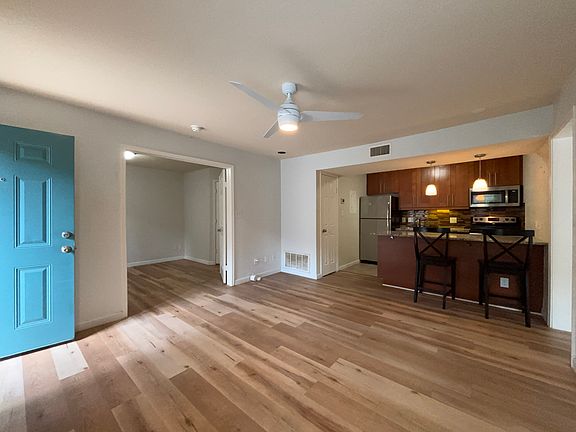 Living open to kitchen. Two chairs at bar may stay