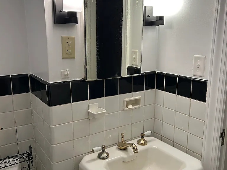 Vintage porcelain sink and tub. Original metal tile work on walls. New sconces