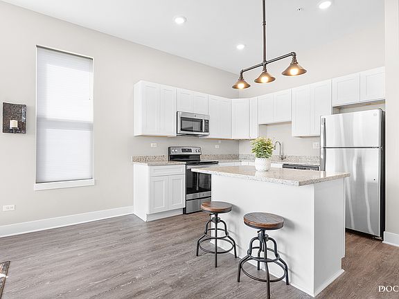 Modern kitchen with granite countertops, soft close cabinets, and stainless steel appliances. Fridge, range/oven, microwave, dishwasher, and garbage disposal included.