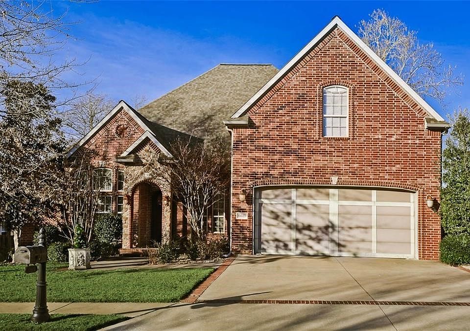 Picturesque Curb Appeal with Decorative Garage Door, Arched Stone Entrance & Gorgeous Mature Trees...