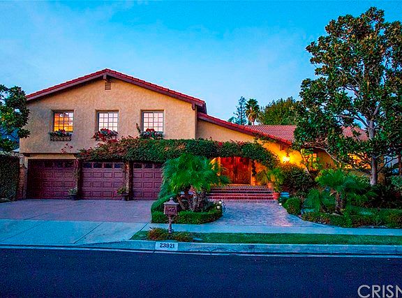 Front Exterior with 3-car garage and lush landscaping