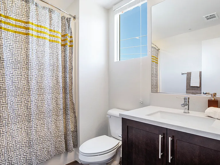 The Harrington bathroom vanity, toilet, and shower with window