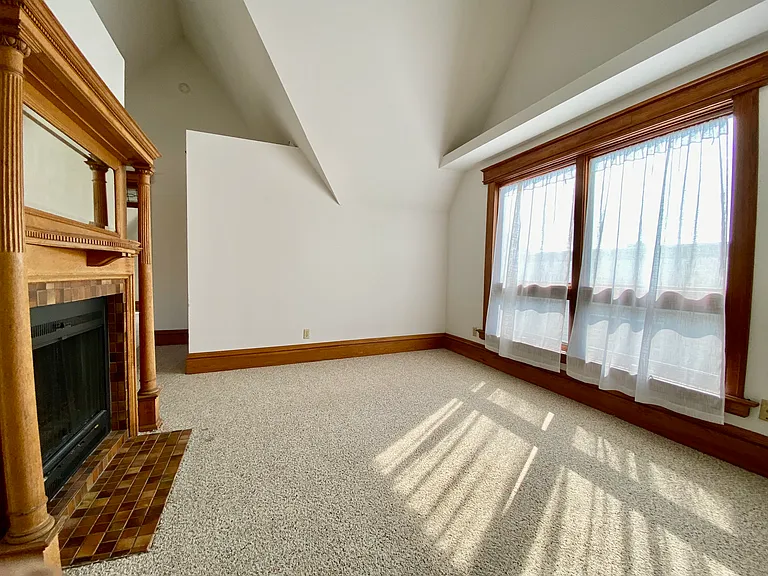 Living room with fireplace (wood-burning). New double-hung windows installed recently; same dimensions, more air flow.