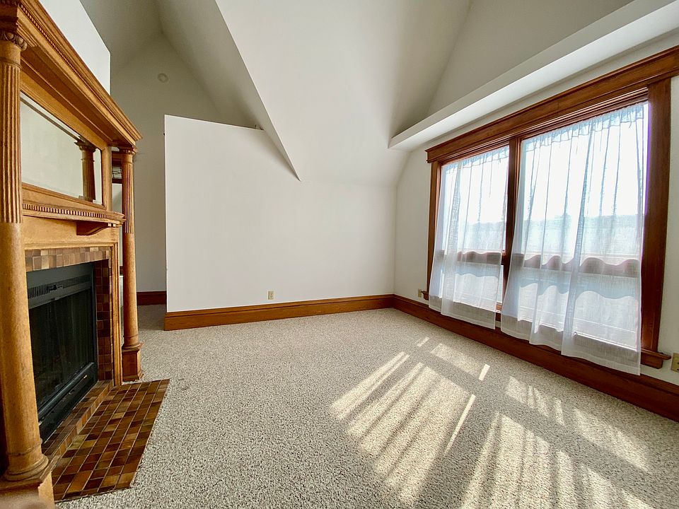 Living room with fireplace (wood-burning). New double-hung windows installed recently; same dimensions, more air flow.