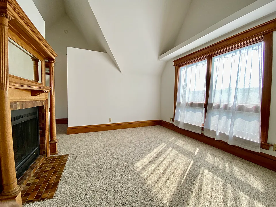 Living room with fireplace (wood-burning). New double-hung windows installed recently; same dimensions, more air flow.
