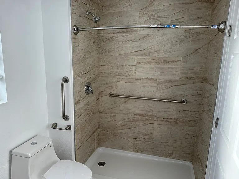 Wheel chair access shower with grab bar