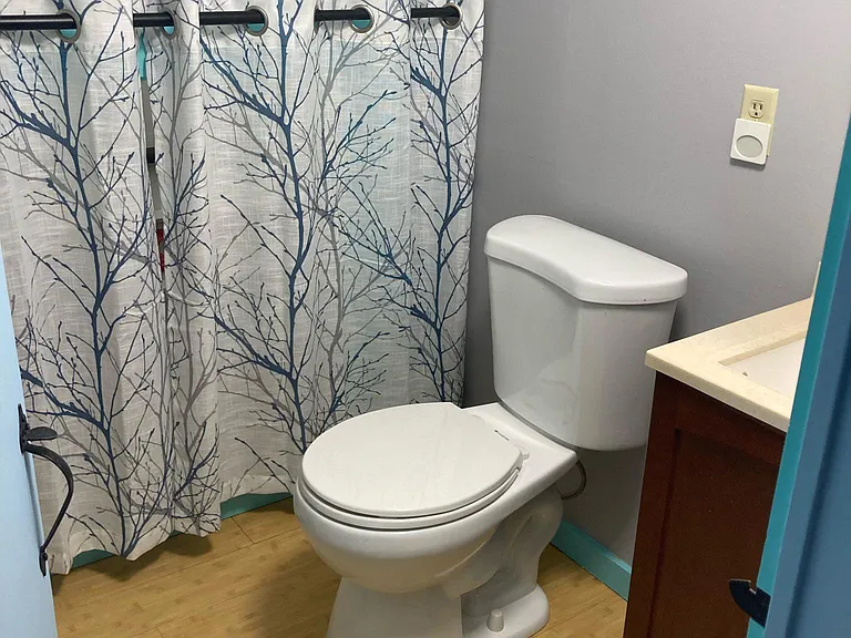 Upstairs half bath, shared by two tenants, lots of storage behind the curtains