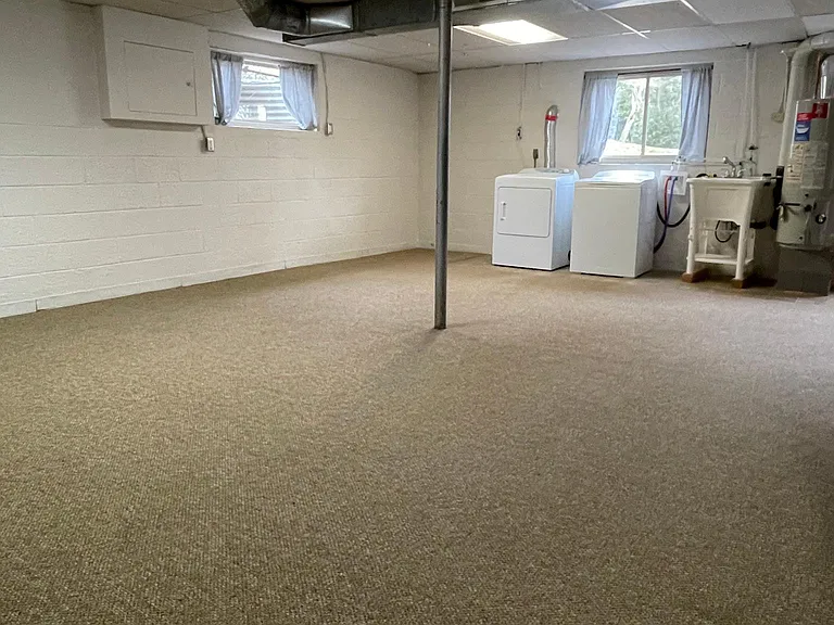 Laundry area with washtub in basement.