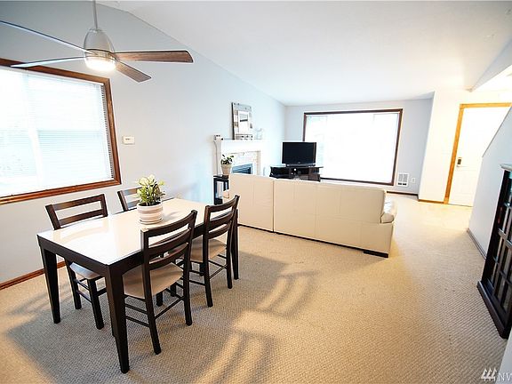 view from dining area to family room. notice large windows & updated ceiling fan!