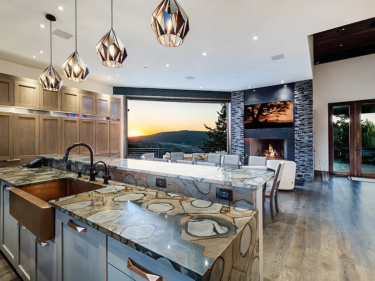 Kitchen with two islands, large dining table, wood burning fireplace, hidden pantry