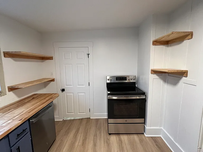 Updated kitchen with open shelving and access to laundry area.