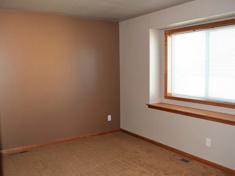 Window seat in bedroom with large window