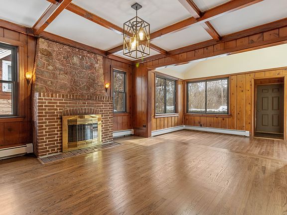 Living room with wood burning fireplace and ample sunlight