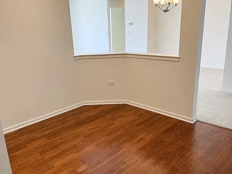 Breakfast area with hardwood floors in spacious and clean kitchen.