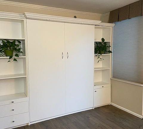 Wall bed with queen sized mattress and built-ins
