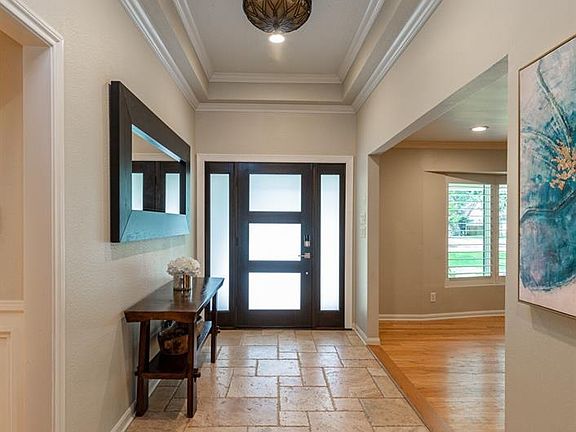 Off-set travertine tile floors welcome you into the lovely home.