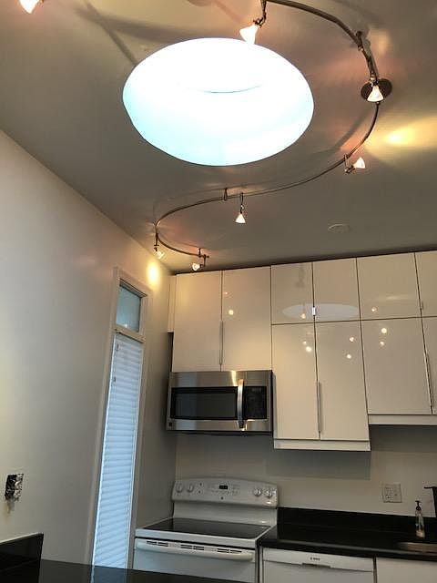 Ceiling height cabinets in kitchen. Round skylight (one of three) and a pantry.