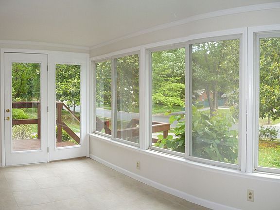 The front porch features sliding glass windows