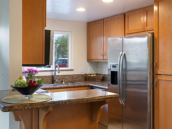 The kitchen boasts granite counters, maple cabinets, stainless steel appliances, and a breakfast bar!