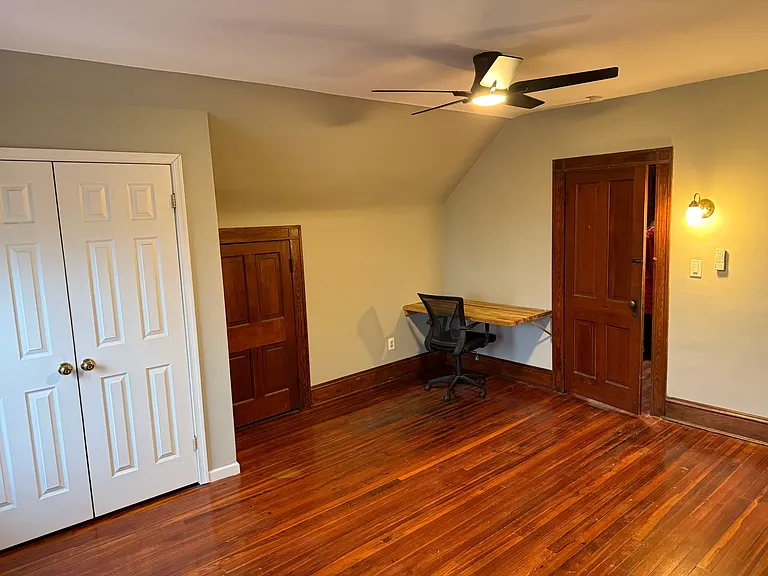 built-in desk in bedroom; closet and two small closets under eaves