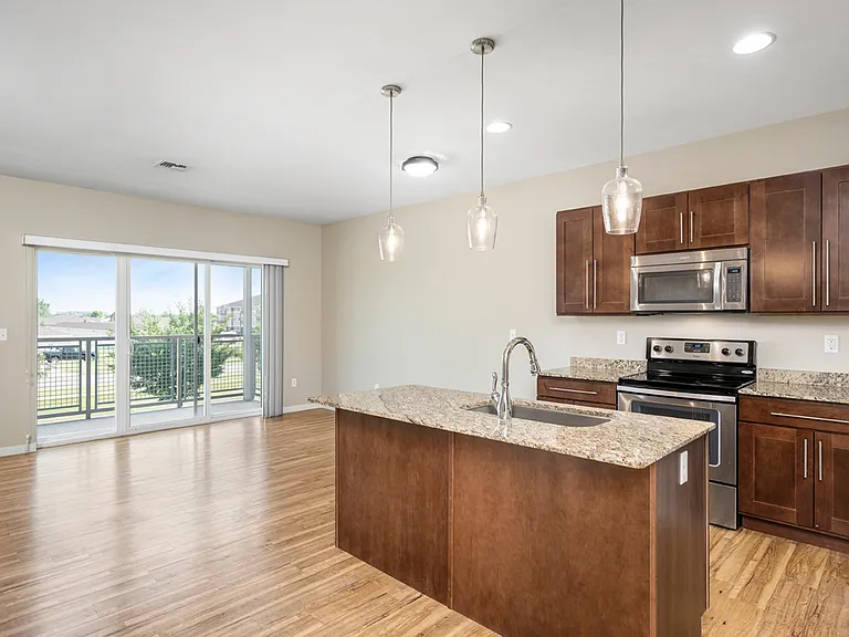 Beautiful open-concept kitchen with modern appliances, elegant pendant lighting, and scenic balcony view. Beautiful open-concept kitchen with modern appliances, elegant pendant lighting, and scenic balcony view.