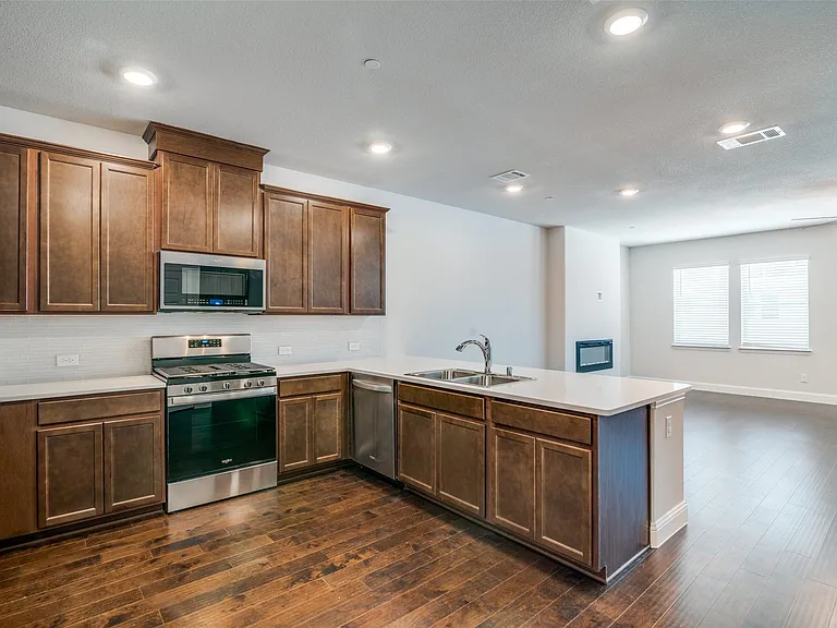 Kitchen featuring wood-finish flooring, stainless steel appliances, white countertops, and recessed lighting
