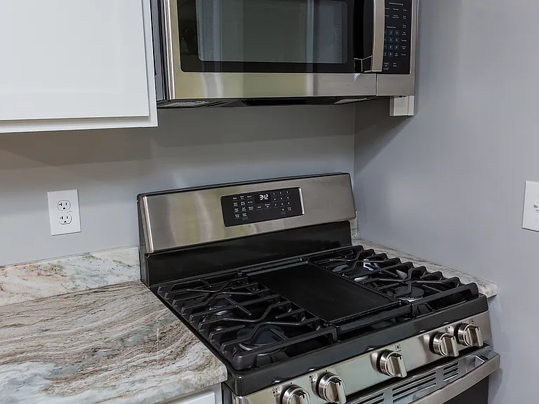 Gas stove and granite counters in kitchen. Some photos are mirror opposite from 201 W High St both finished the same inside.