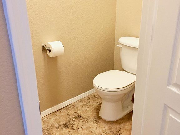 Private master bath toilet with door.