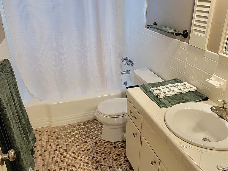 Unwind and relax in the quiet restroom area with new towels, shower curtain, rug and decor