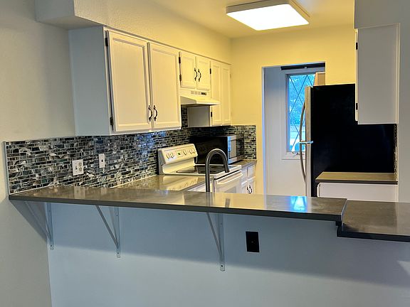 Freshly renovated kitchen in May 2024, newly painted cabinets, tile backsplash, granite countertops, brand new sink with pressure sprayer.