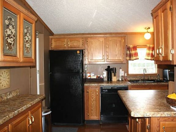 Large L-shaped kitchen features new countertops and loads of oak cabinetry. All appliances are included.