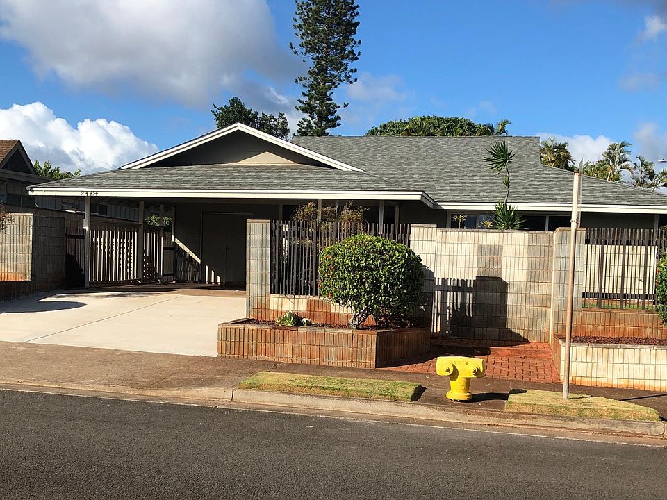 Front of House with covered carport and enclosed refuse area