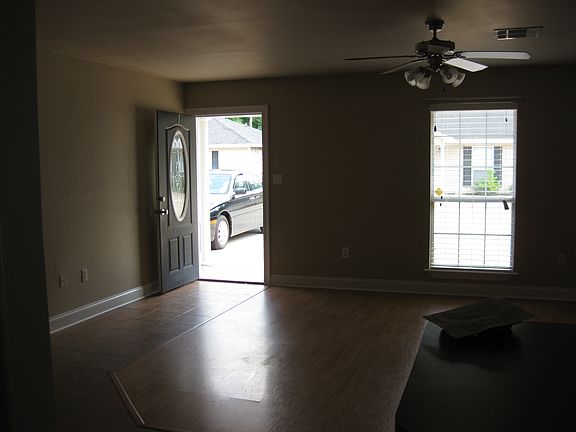 Large living room with wooden floors and ceiling fan