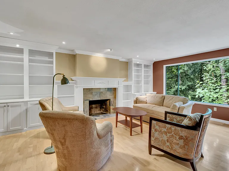 Formal living room with built-in library and fireplace. Hardwood floors throughout.