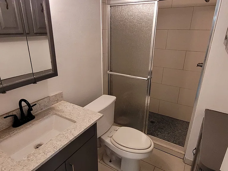 Newly tiled bathroom with shower. Has a new, powerful tankless water heater.