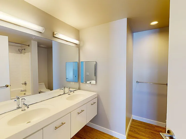 Bathroom with wood-style flooring and double sinks.