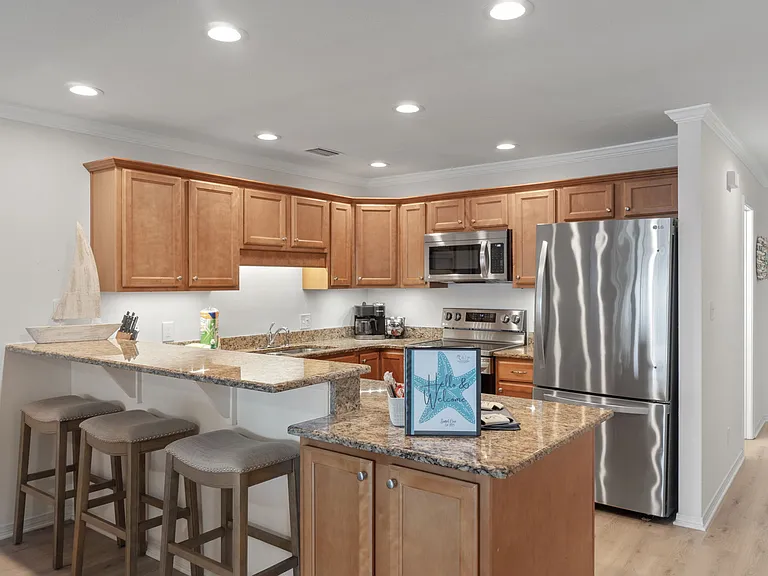 Fully functioning kitchen with modern appliances. Bar seating for 3
