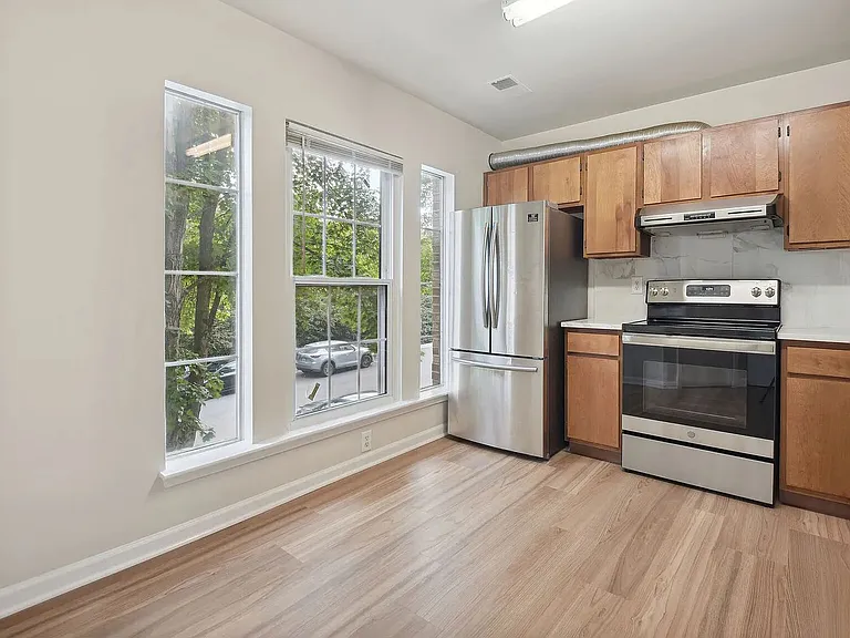 Overview of the kitchen showing its stainless steel appliances and the natural light let in by the ample windows on the south wall of the lower level.
