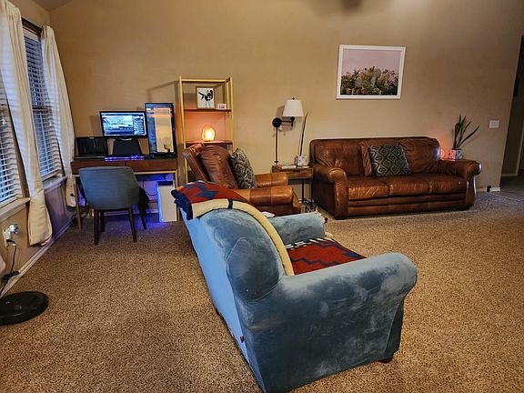 Desk in living room and windows into the backyard.