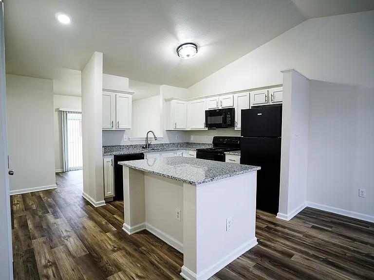 A spacious kitchen with a large island opens effortlessly into the living and dining areas at The Bristol, creating the perfect setup for gatherings and easygoing living.