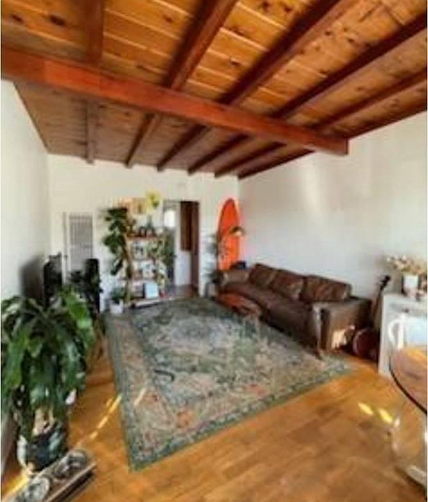 Amazing living room with wood beam ceiling and wood floors great with any decor!