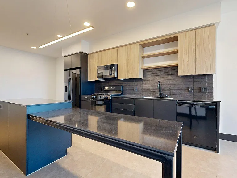 Apartment Kitchen with large counter tops and Wood-Style Flooring.