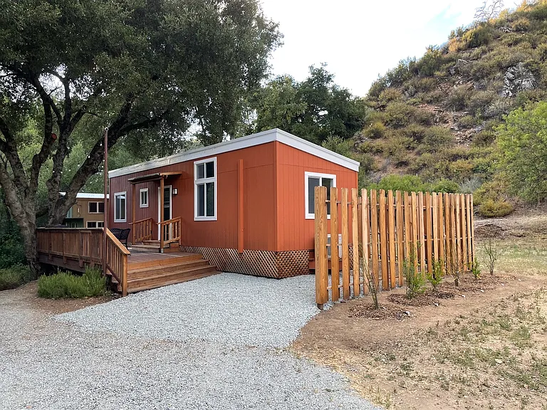 Entry to the home with front deck, privacy fence surround, and serene mountain vistas.