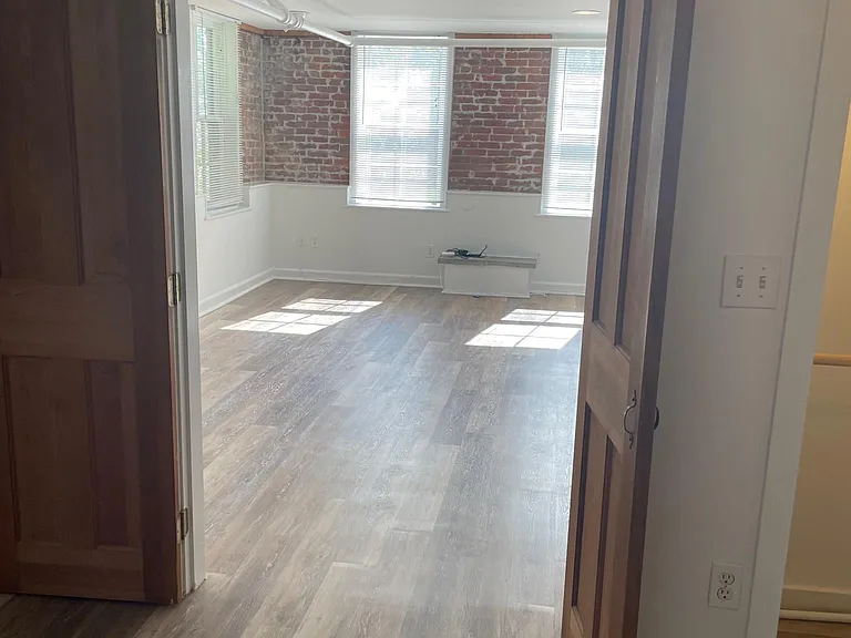 Bedroom with large double door looking into living room.