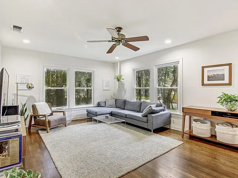 Bright Open Concept Living Room with Large Windows, Ceiling Fan, Hardwood Floors